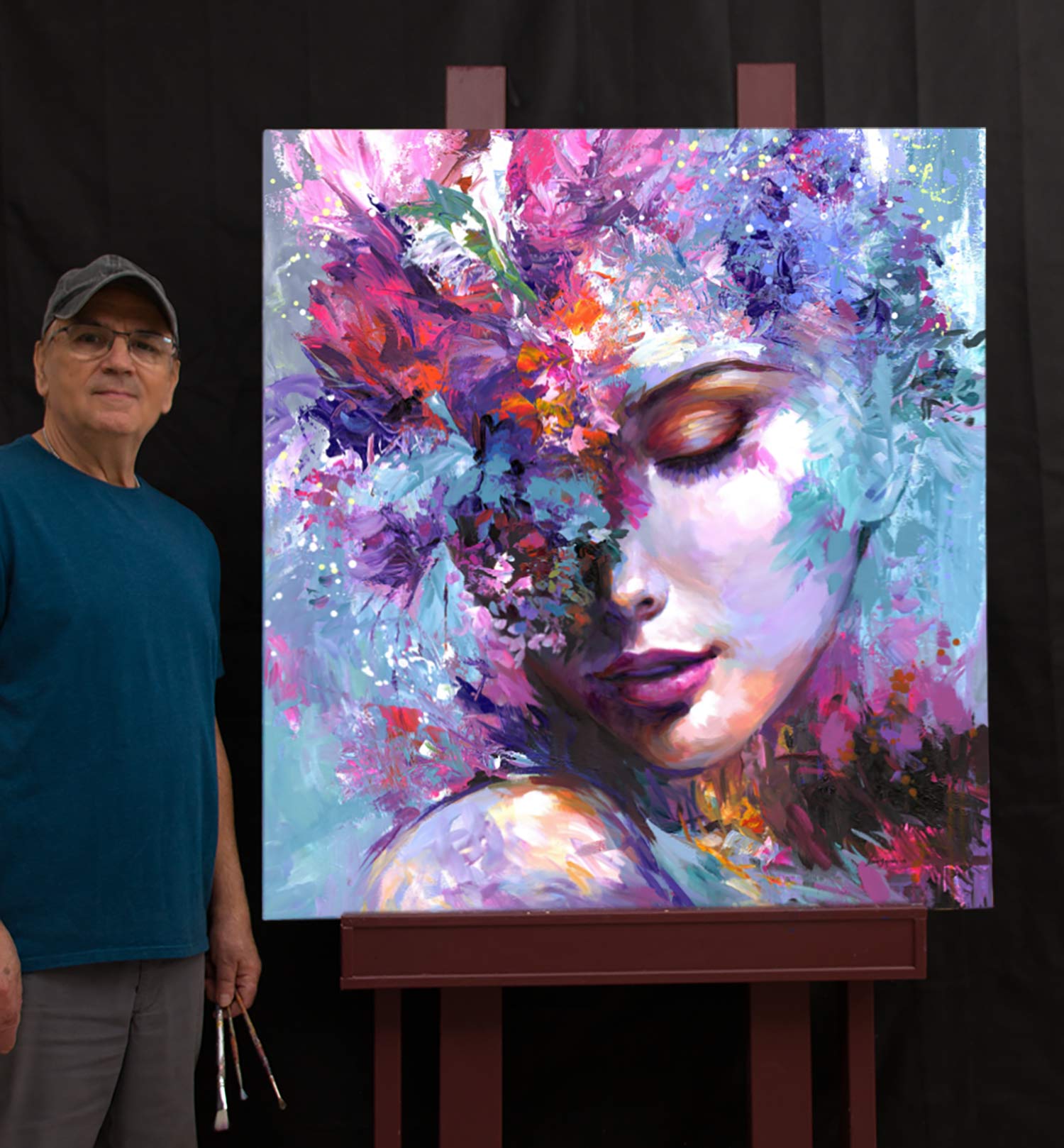 The artist Leon Devenice standing beside colorful artwork on easel